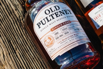The bottle image of the new TWS Old Pulteney lying on a wooden background 